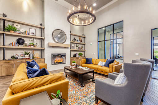 A living room with a yellow couch, a grey armchair, and a coffee table.