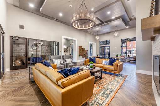 A living room with a tan couch and a rug.