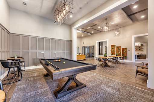 A billiard table is in the middle of a room with a pool table.