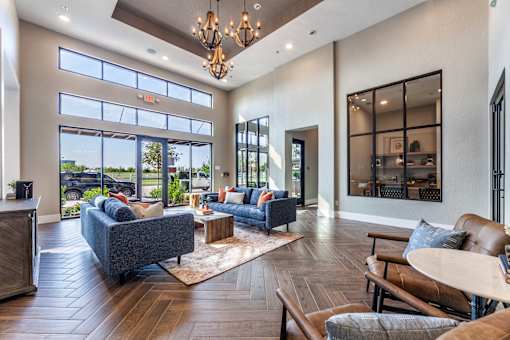 A living room with a grey couch and a wooden floor.