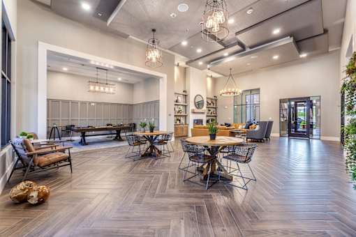 A modern living room with a dining area and a kitchen in the background.