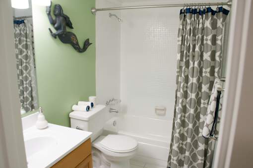 A bathroom with a green wall and a white toilet.