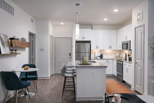A modern kitchen with a breakfast table and chairs.