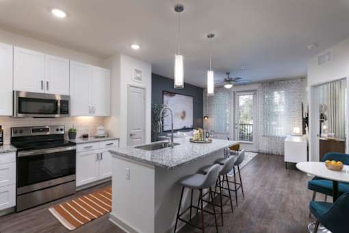 A modern kitchen with white cabinets and a large island.