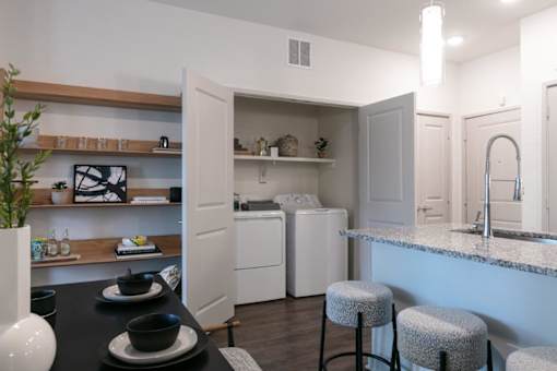 A kitchen with a black table and white appliances.