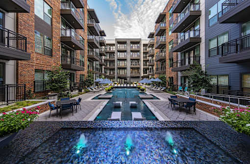 A fountain in the middle of a courtyard surrounded by buildings.