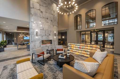 A modern living room with a stone fireplace and a large sectional sofa.