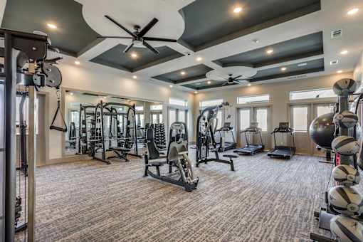 A spacious gym with a variety of equipment including treadmills, weights, and exercise machines.
