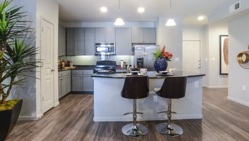 a kitchen with a bar and stools in front of a counter top