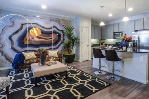 a living room with a kitchen and a rug