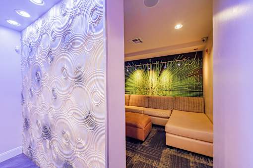 A room with a patterned wallpaper and a couch.