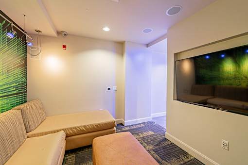 A living room with a couch, a coffee table, and a television.