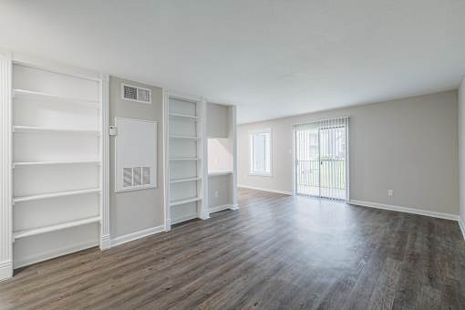 A large, empty room with wooden floors and white walls.