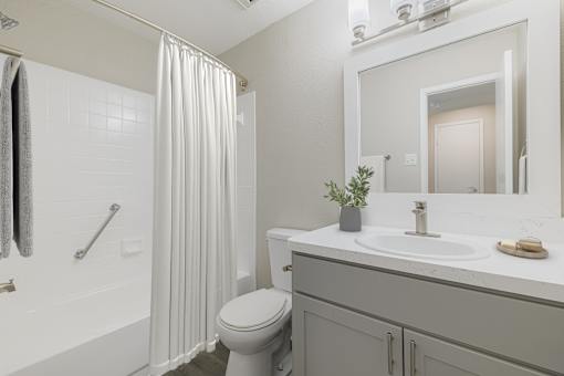 A bathroom with a toilet, sink, and shower.