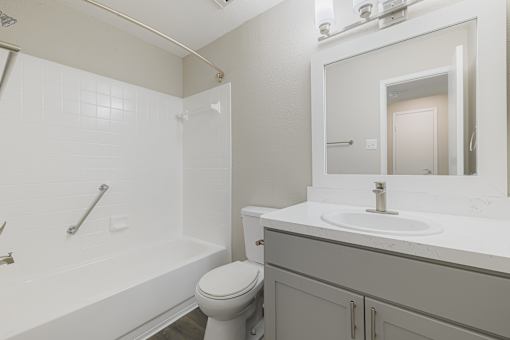 A white bathroom with a toilet, sink, and bathtub.