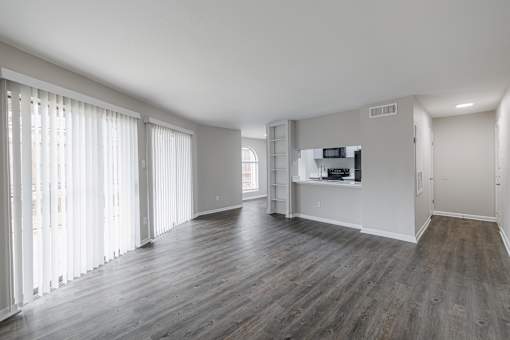 A spacious room with wooden floors and white walls.