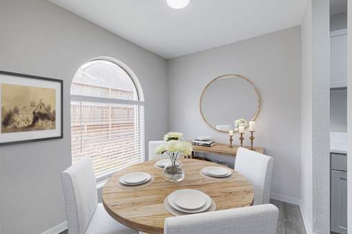 A dining room with a round table and chairs.