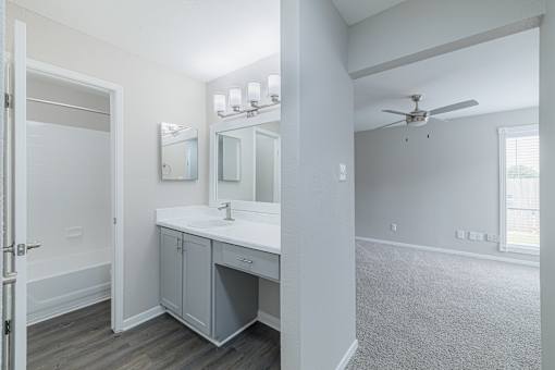 A bathroom with a sink, mirror, and cabinet.