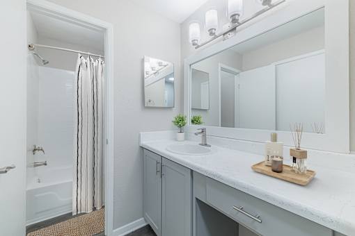 A white bathroom with a white sink and a white counter.