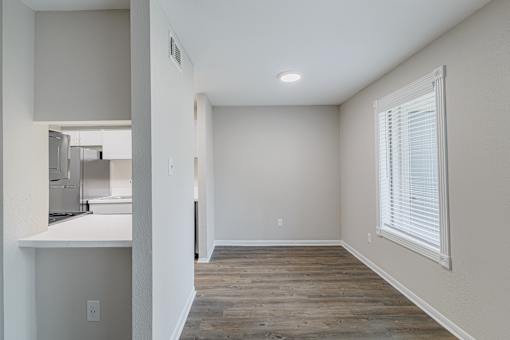 A room with wooden flooring and white walls.
