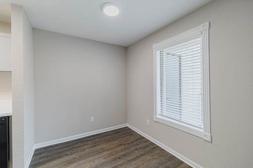A room with a window and wooden flooring.