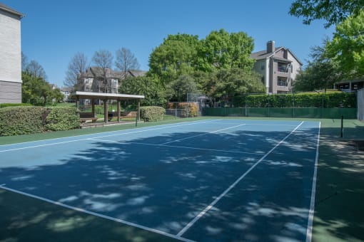 a tennis court at the whispering winds apartments in pearland, tx