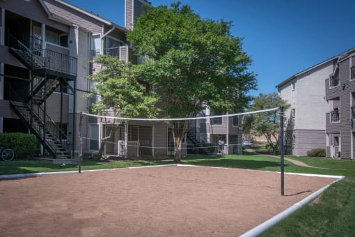 a volleyball court at the whispering winds apartments in pearland, tx