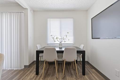 A dining room with a table and chairs.