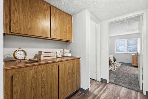 A room with wooden cabinets and a clock on top of one of them.