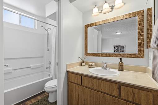 A bathroom with a white toilet and a wooden vanity.