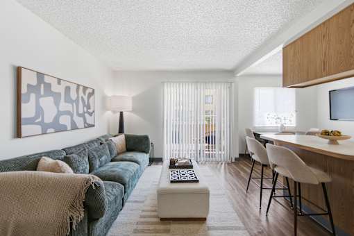 A living room with a couch, a coffee table, and a painting on the wall.