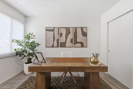 A brown table with a vase and a plant on it.