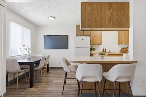 A modern kitchen with a dining table and chairs.