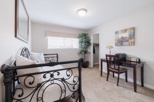 a bedroom with a bed and a table and a window