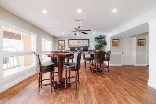 a dining room with a table and chairs and a kitchen with a ceiling fan