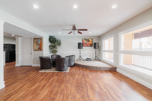 a living room with a ceiling fan and a drum kit