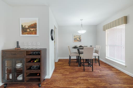 a dining room with a table and chairs and a kitchen with a large window