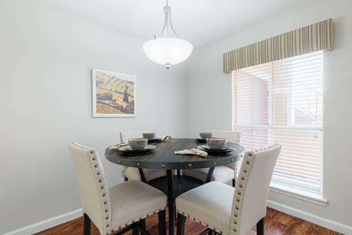 a dining room with a table and chairs and a large window