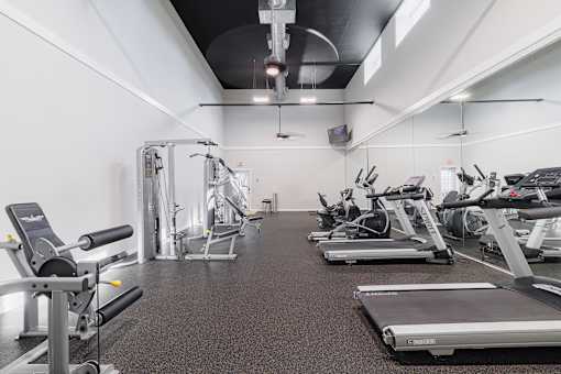 A gym with treadmills, elliptical machines, and other cardio equipment.