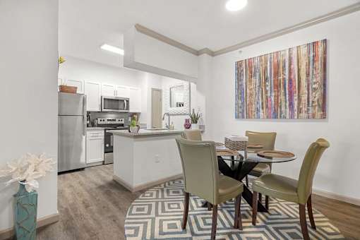 A kitchen with a dining table and chairs.