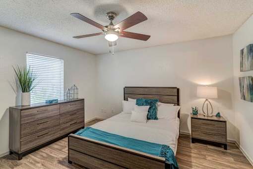 A bedroom with a bed, dresser, and nightstand.