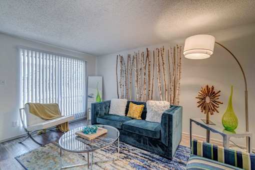 A living room with a blue couch and a yellow chair.