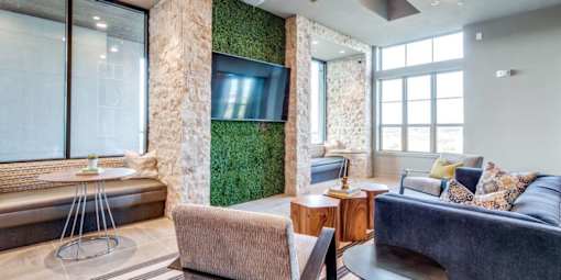 A living room with a couch, a chair, a table, and a green wall.