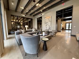 A spacious room with grey chairs and a patterned rug.