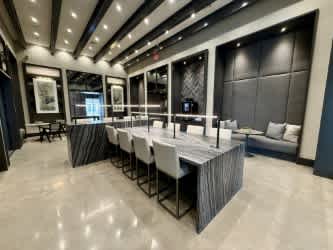 A modern dining room with a long table set for a meal.