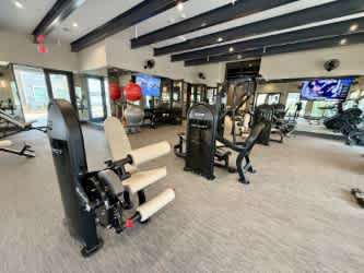 A gym with a variety of equipment including treadmills, weights, and exercise machines.