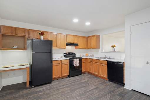 A kitchen with black appliances and wooden cabinets.