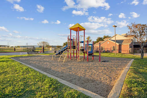 A playground with a yellow and red slide and a yellow and red structure.