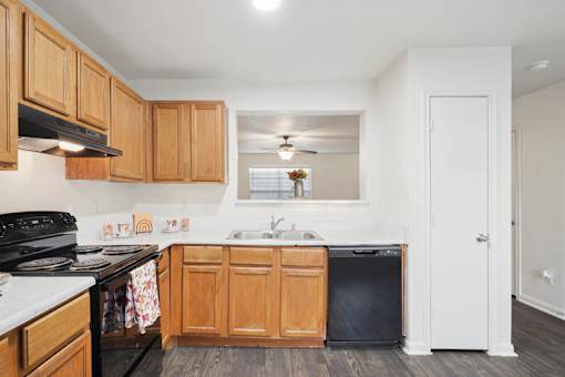 A kitchen with wooden cabinets and a black stove top oven.