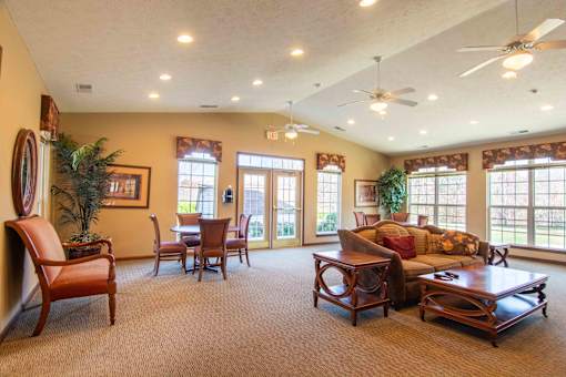 A living room with a brown carpet and wooden furniture.